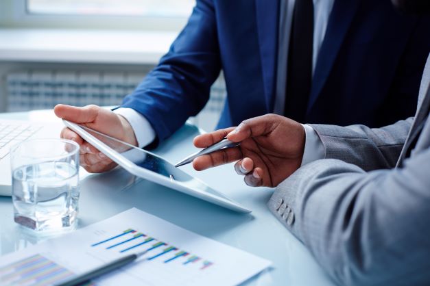 image-of-businessmen-discussing-data-in-touchpad-at-meeting-SBI-300726656