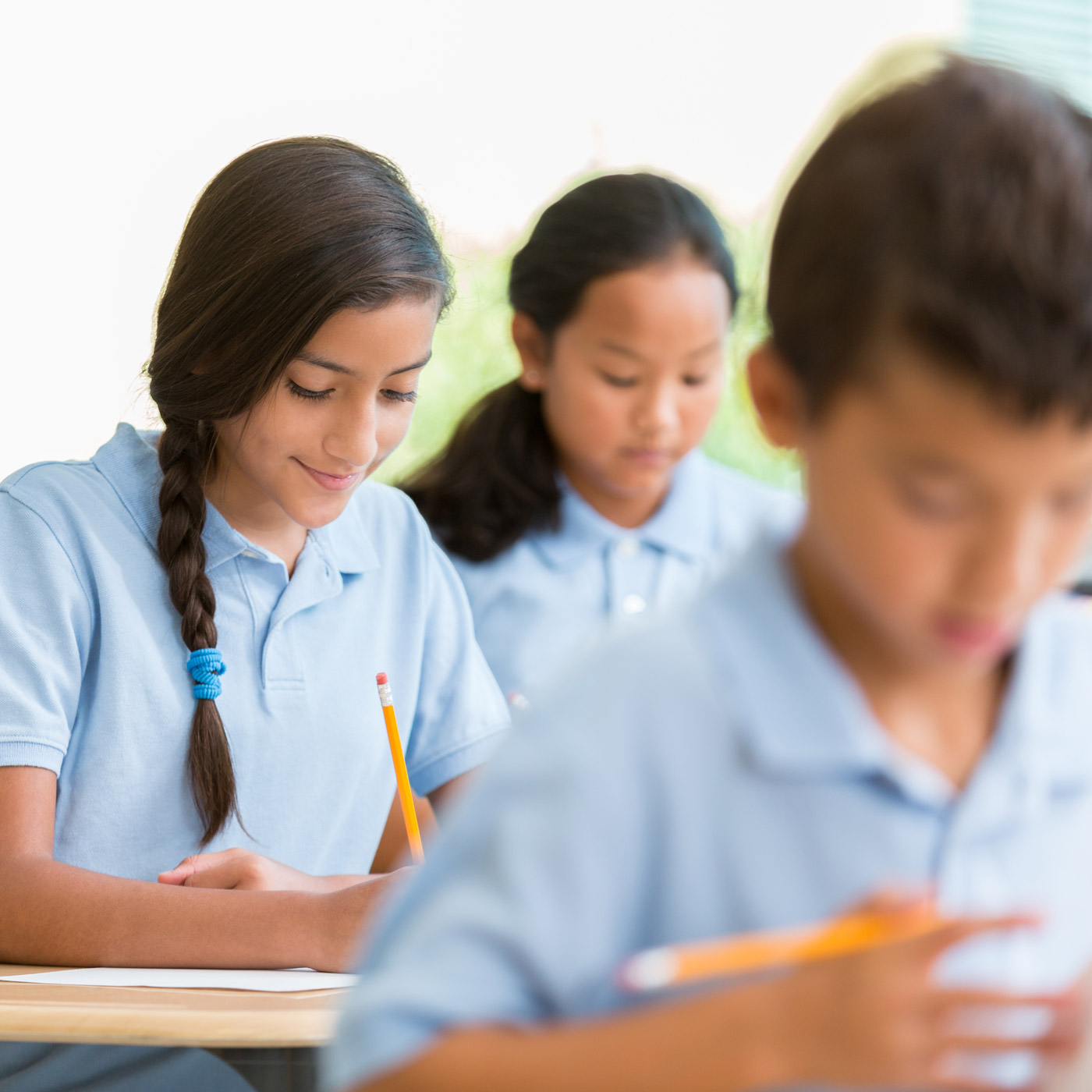 Private school students at their desks writing