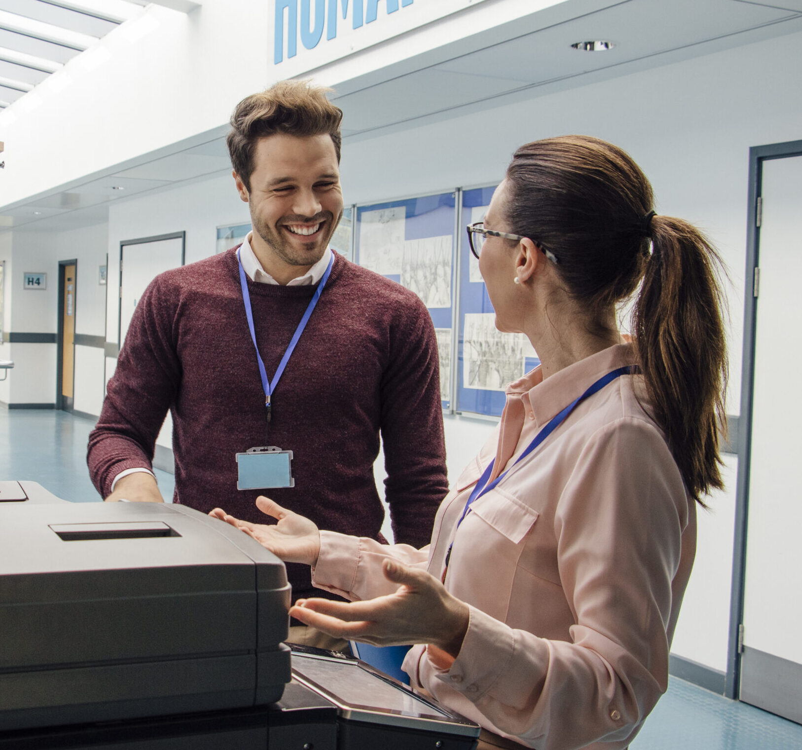 An IT Director helping a colleague operate a printer