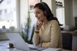 A woman tuning in to the Ravenna Enrollment Trends Webinar